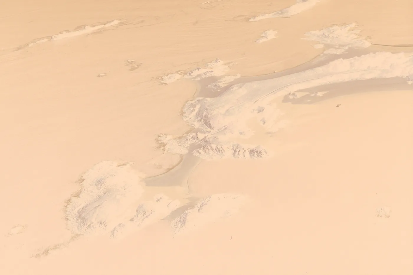 The raw scan of the islets: the sea is a dull orange-red, the rocks pale, the sand dark, under the orange base.