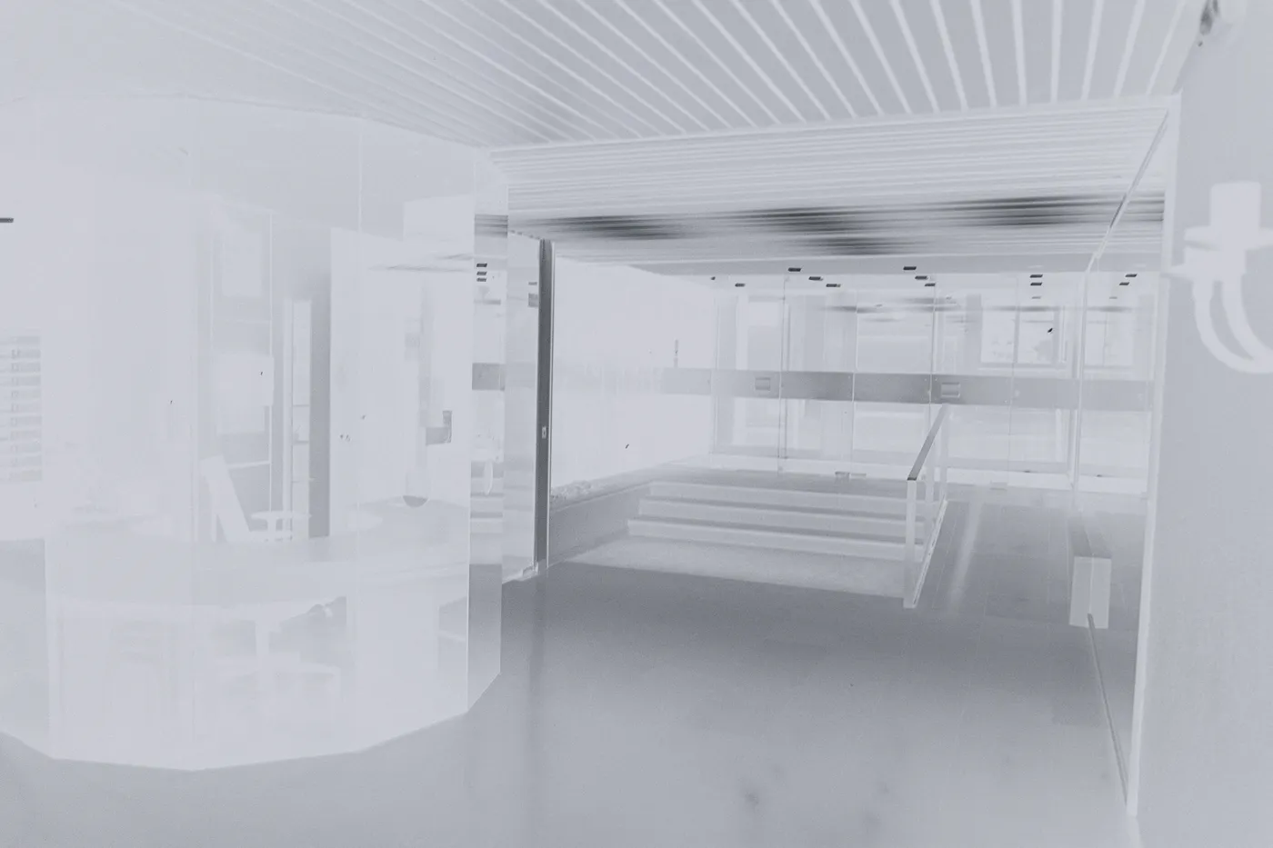 The raw scan of the lobby: tones reversed, the white floor black and the dark glass pale, on the clear base of a black and white film.