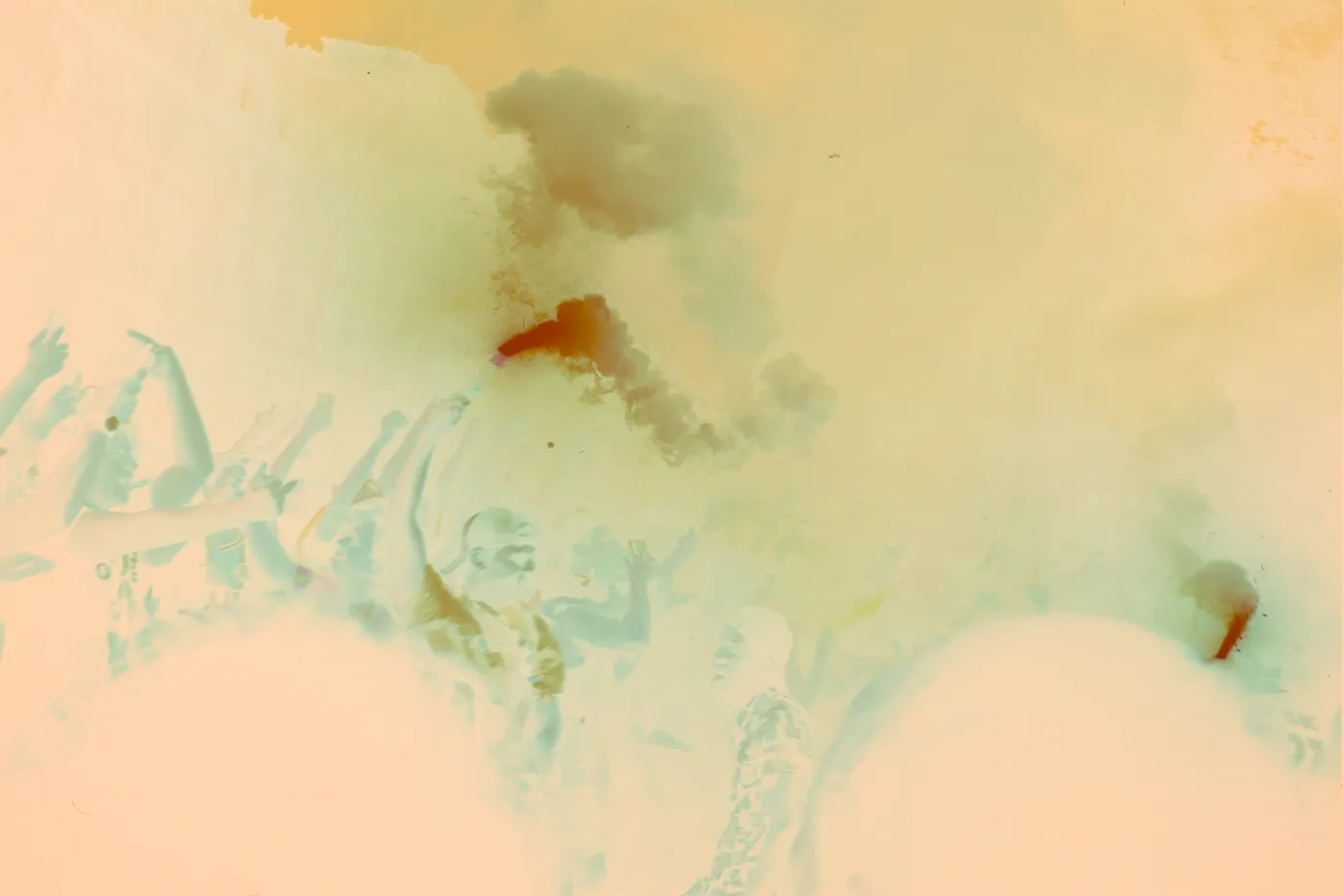 The raw scan of the same crowd: the smoke reads as a dark cyan cloud and the crowd as pale shapes, under the orange base of the film.